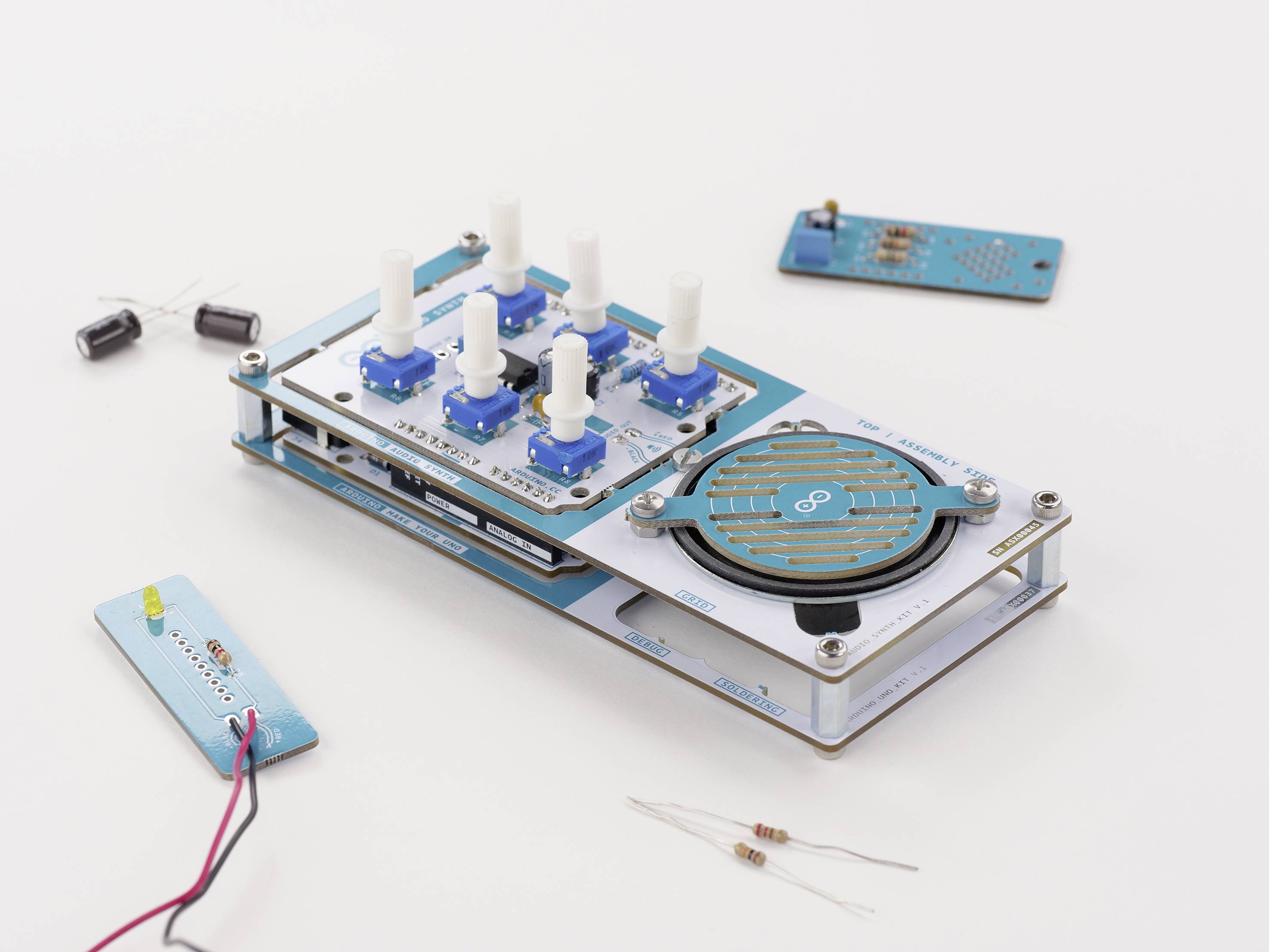 Experimentální Arduino sada na bílém pozadí, skládající se z různých elektronických komponent a obvodů.