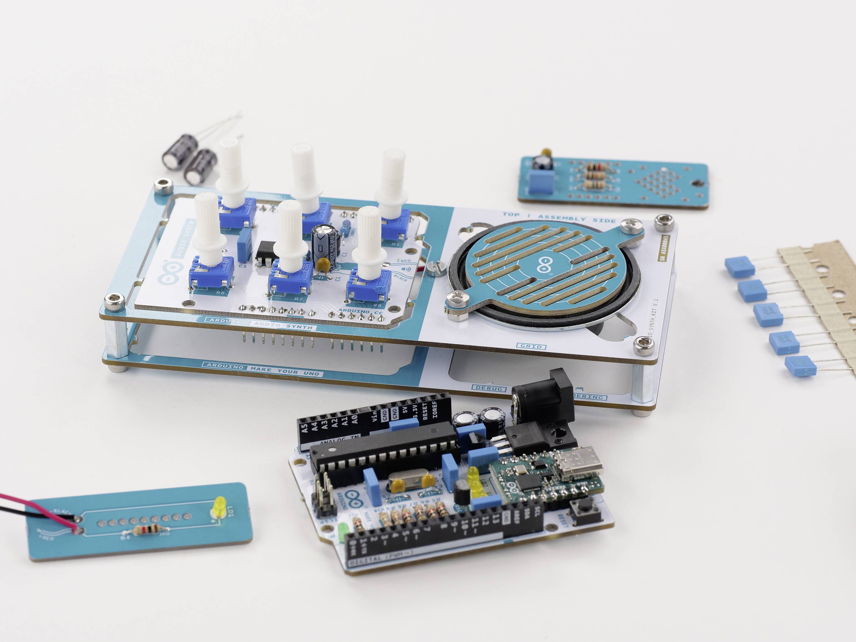 Elektronické komponenty na stole, včetně mikrokontroléru, senzorů a obvodů, vhodné pro projekty Arduino.