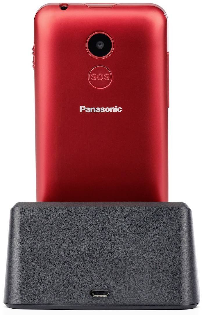 Červený mobilní telefon na nabíjecí stanici s tlačítkem SOS na zadní straně.