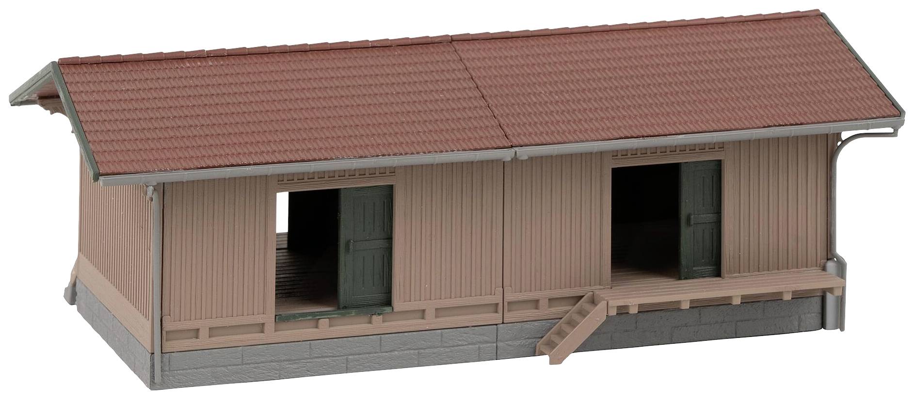 Malý model skladu s červenou cihlovou střechou a dřevěnou strukturou. Dva vchody a malé schody vedou dovnitř.