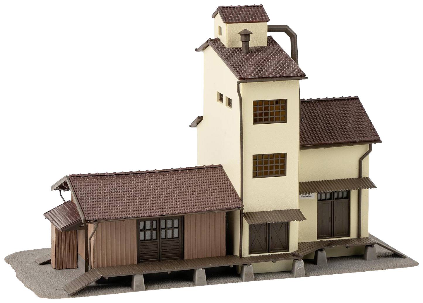 Model budovy zobrazuje obilný silo s přistavěným skladem. Má béžové stěny a hnědou šikmou střechu.