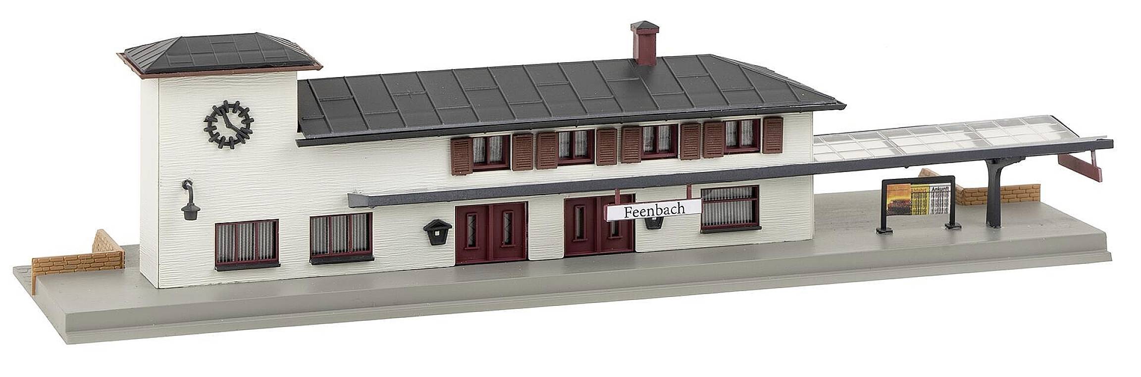 Model nádraží se dvěma patry, věží s hodinami, dvěma vstupy a krytým nástupištěm. Cedule ukazuje nápis 'Freibach'.