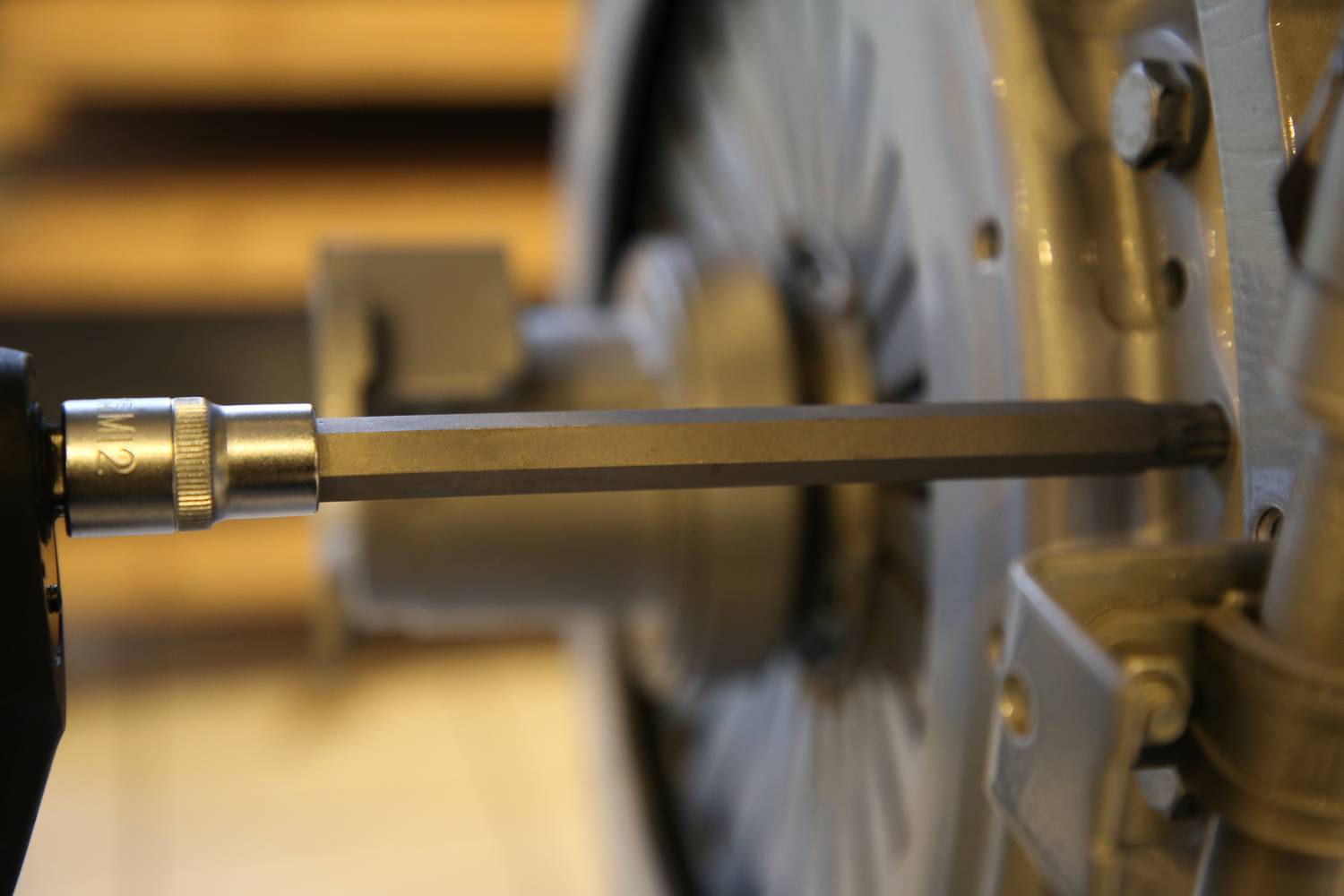 Detailní pohled na momentový klíč nastavovaný na stroji s několika šrouby. Důraz na přesnost a mechaniku.