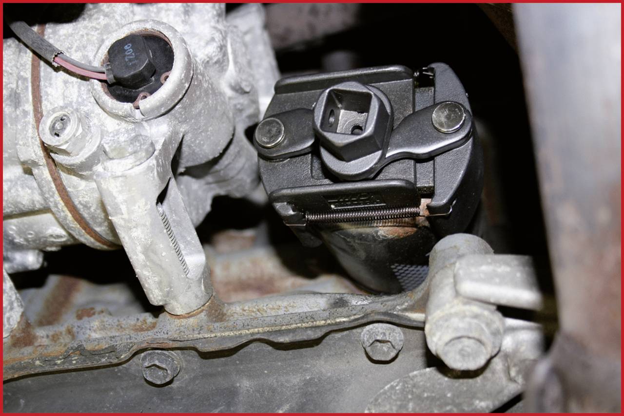 Detailní záběr strojní součásti s viditelnými šrouby a elektrickými konektory.