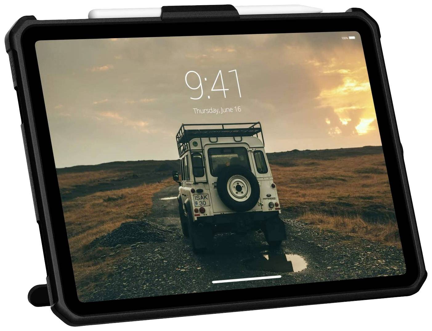 Tablet v ochranném obalu zobrazuje obrázek terénního vozu na štěrkové cestě za soumraku.