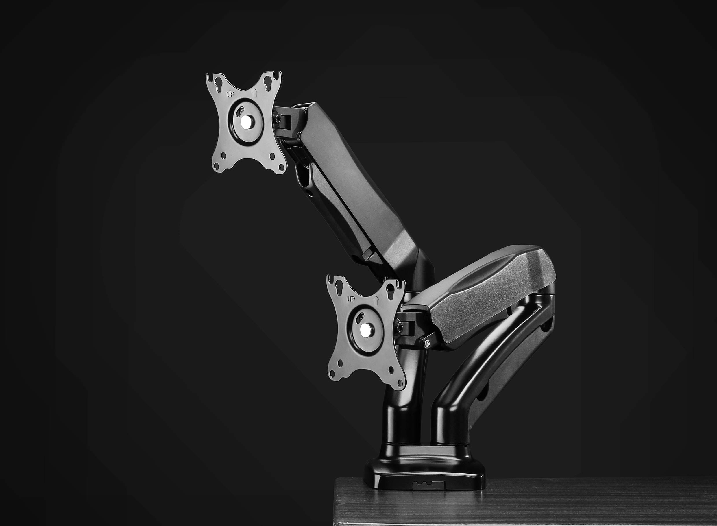 Černý duální držák monitorů z kovu upevněný na stole, umožňující flexibilní otáčení a naklápění pro dva monitory. Ideální pro ergonomická pracoviště.