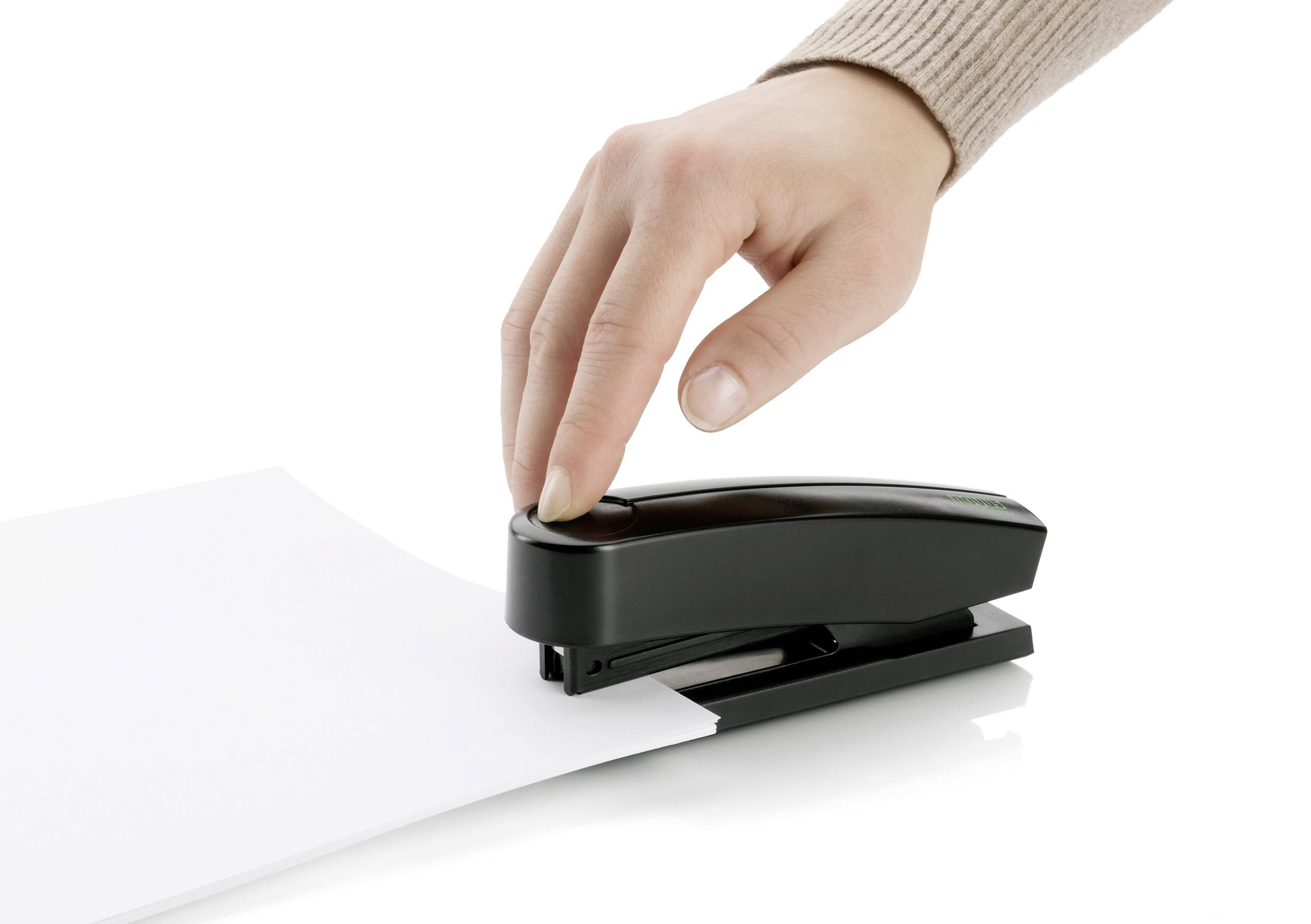Jedna ruka obsluhuje černou sešívačku, aby sešila několik bílých listů.