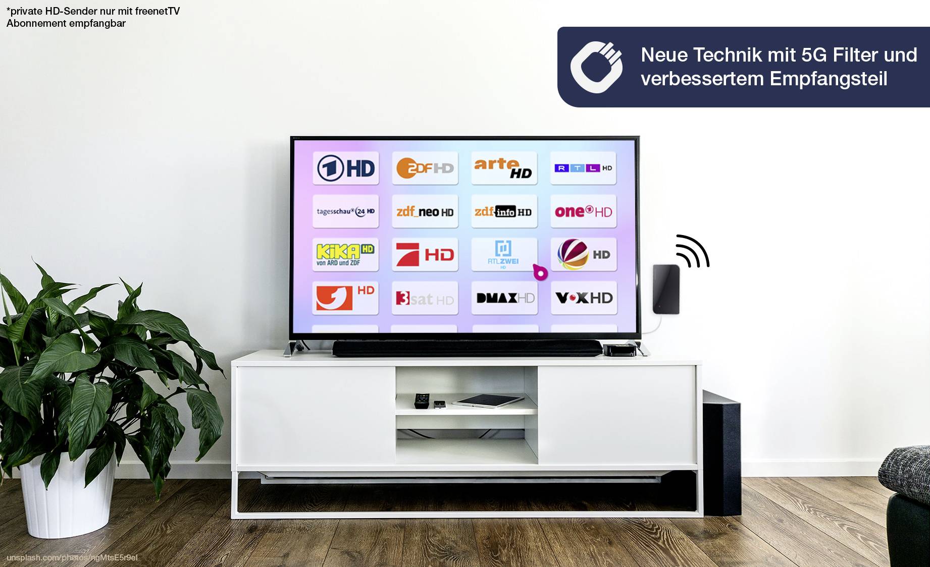 Televizor umístěný na bílém stole zobrazuje různá loga televizních stanic. Text upozorňuje na 'Novou techniku s 5G filtrem a vylepšenou přijímací částí'.