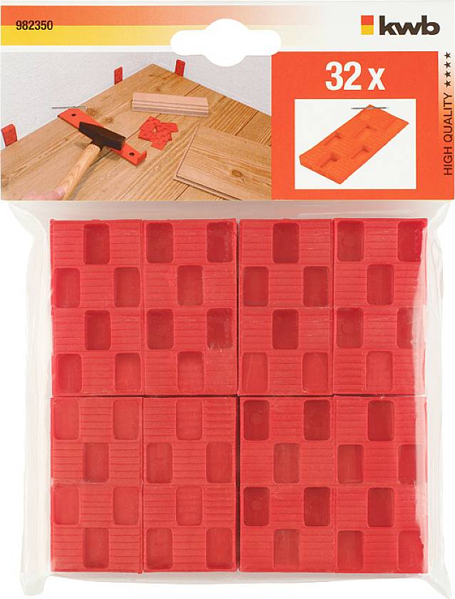 Balení 32 červených plastových klínů na pracovním stole s kladivem. Používá se pro vyrovnávací práce ve stavebnictví. Název produktu: 'High Quality'.