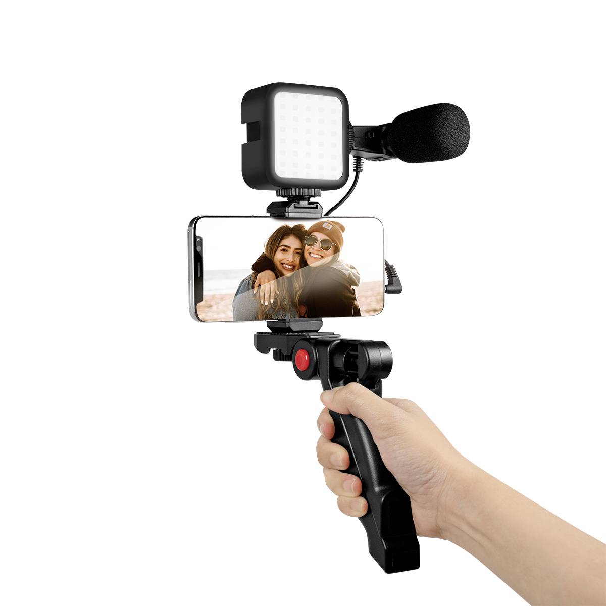 Jedna ruka drží smartphone na stativu, s mikrofonem a světlem, zatímco zobrazuje fotografii dvou se usmívajících osob.