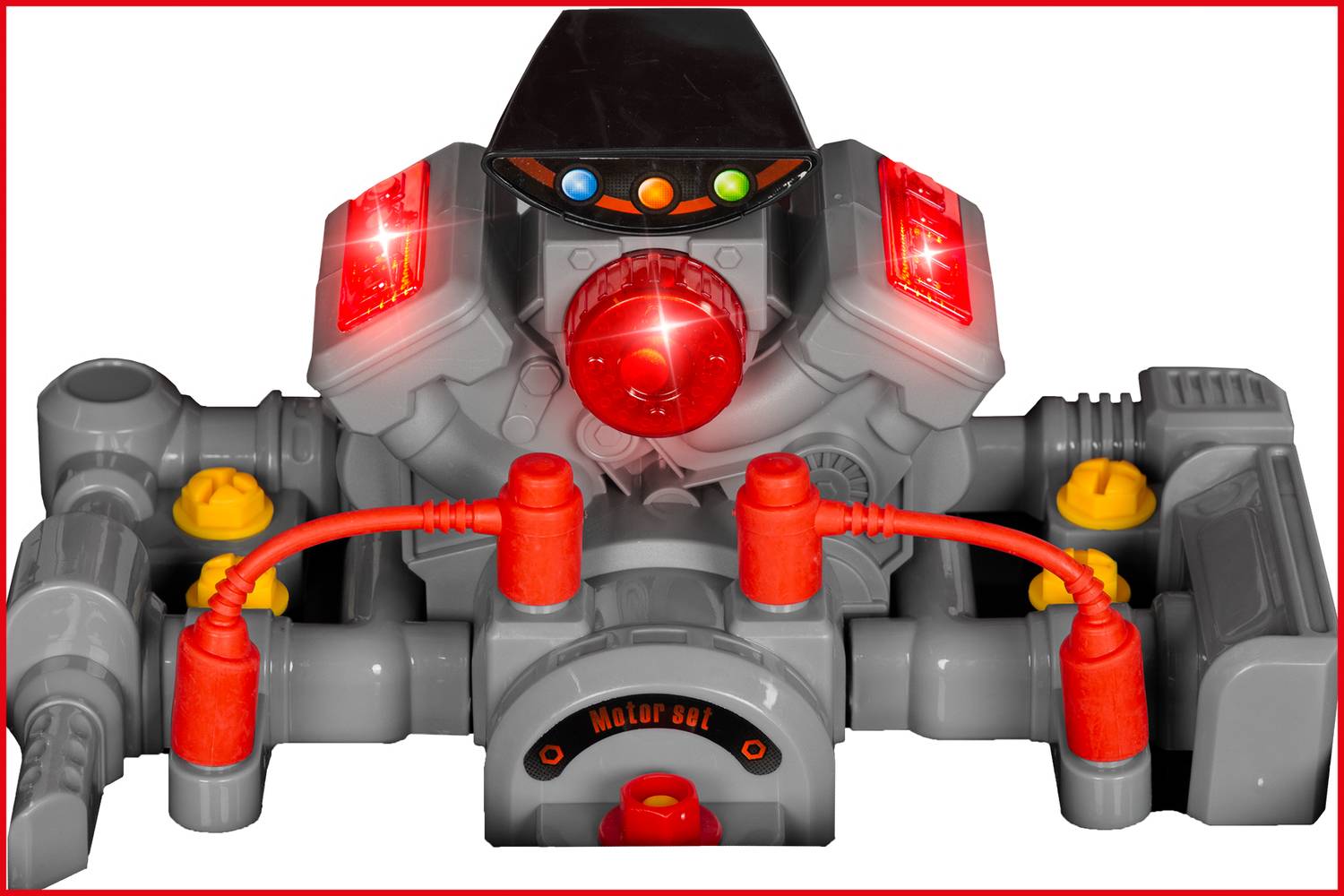 Šedý a červený hračkářský robot s osvětlenými tlačítky a světly. Vypadá futuristicky, jako by uchovával energii.