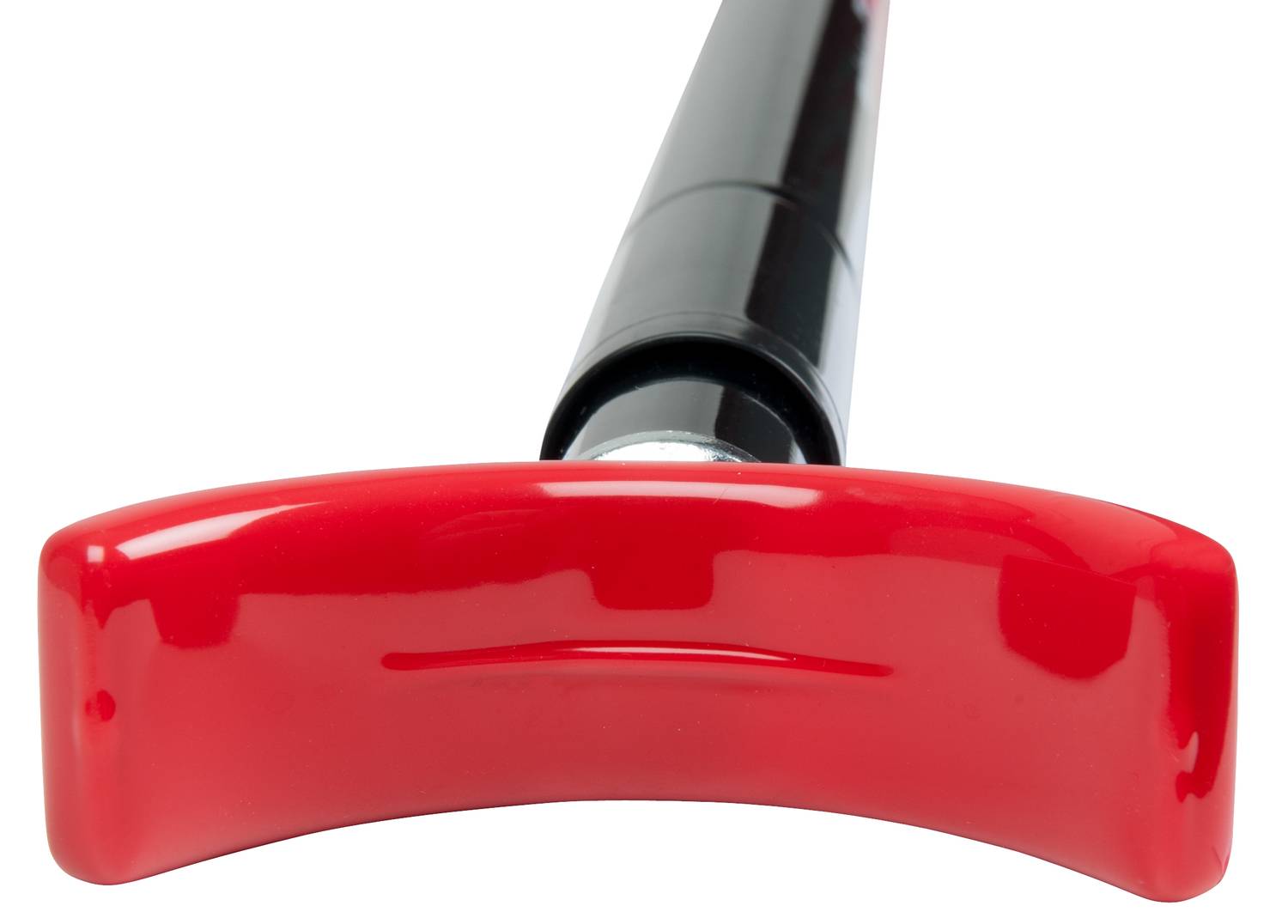 Červená rukojeť nástroje, detail zblízka, ukazující tvar a texturu rukojeti.