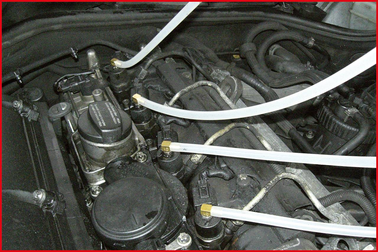 Motorový prostor vozidla s připojenými plastovými trubkami v různých místech motoru.