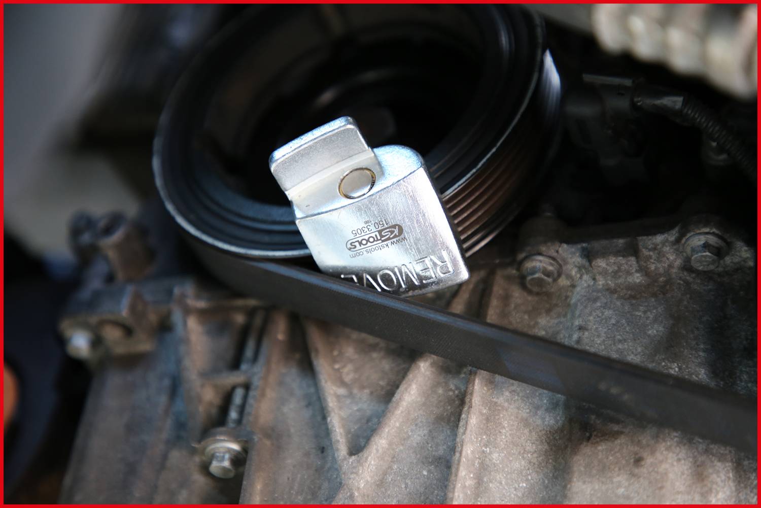 Nástroj na demontáž řemenice je připevněn k motoru. Ukazuje použití speciálního nástroje pro demontáž.