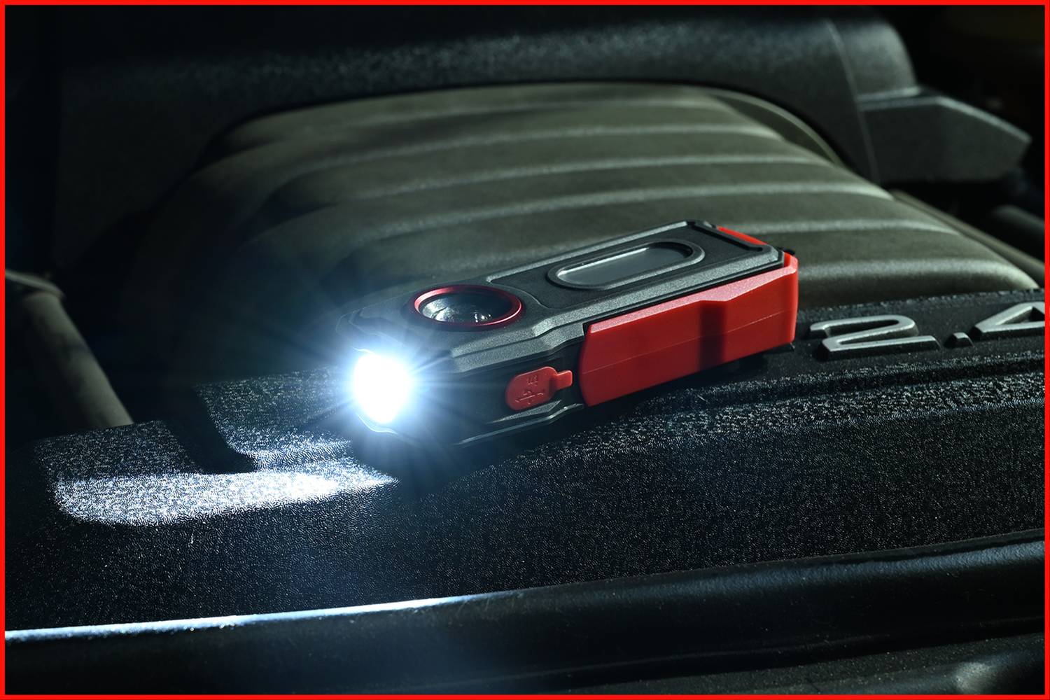 Svítící baterka leží na sedadle automobilu s překrytým motorovým prostorem a osvětluje bezprostřední okolí.