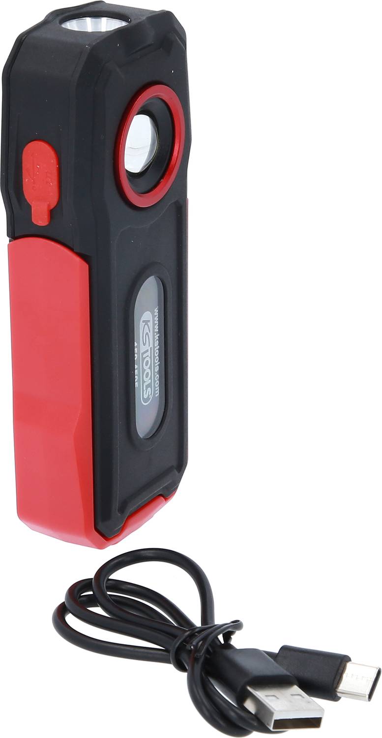 Červená kapesní svítilna s černou rukojetí a integrovaným USB nabíjecím portem, vedle které leží USB nabíjecí kabel.
