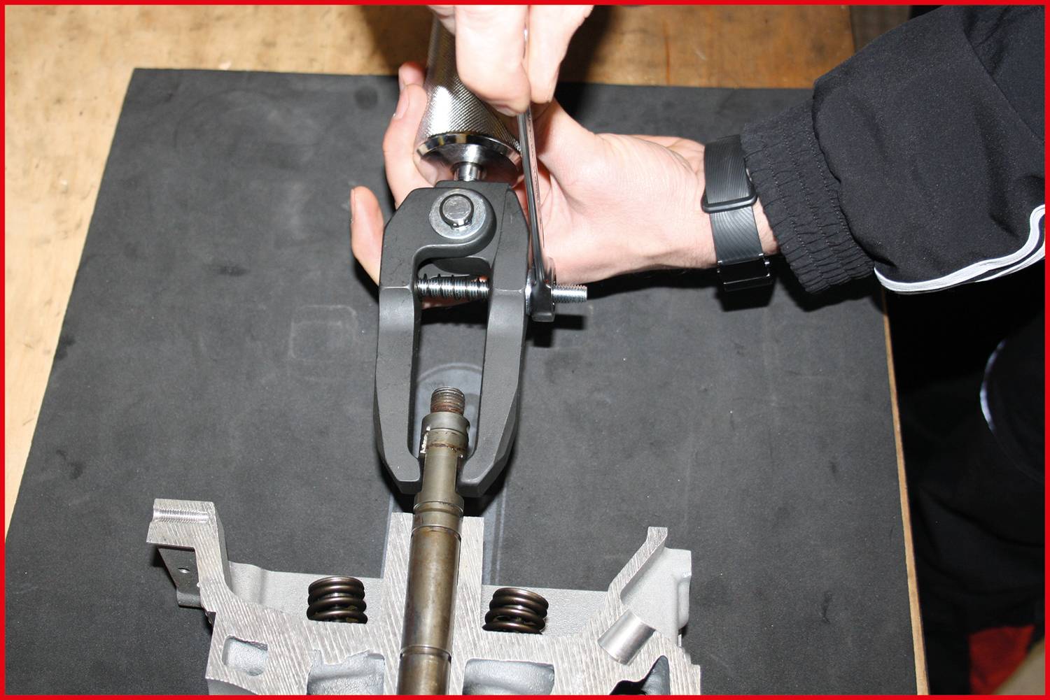 Ruka utahuje šroub pomocí nástroje na mechanické součásti.