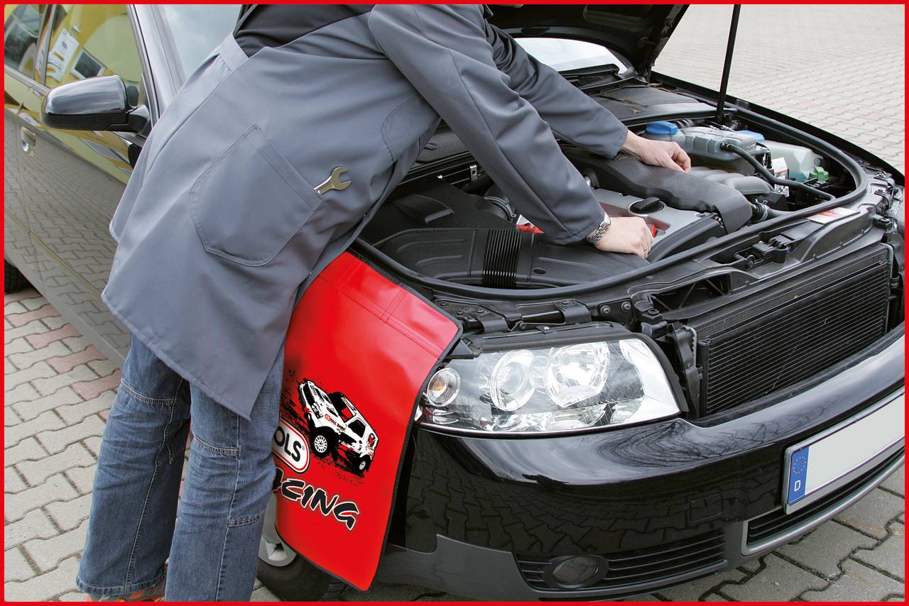 Člověk opravuje automobil, otevřená kapota, zaměření na motorový prostor. Na blatníku leží ochranná podložka s motivem závodního vozu.