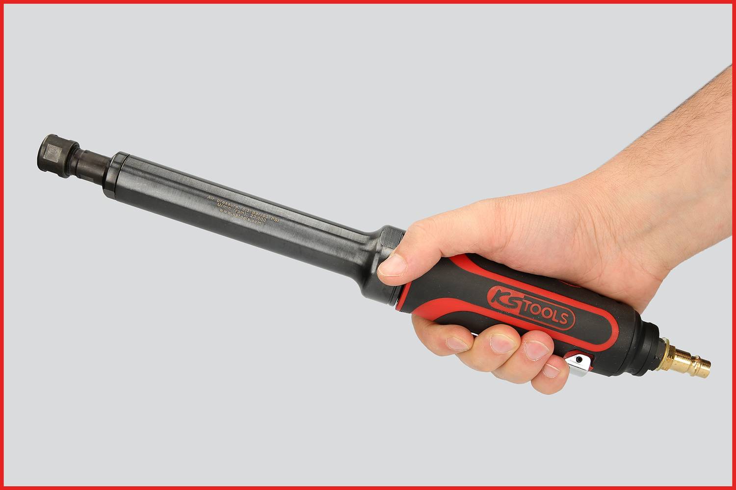 Jedna ruka drží pneumatický rázový utahovák s černou a červenou rukojetí, na které je napsáno 'KS TOOLS'.