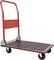 Červený plošinový vozík s černou ložnou plochou a čtyřmi koly, vhodný pro přepravu těžkých předmětů ve skladu nebo dílně.