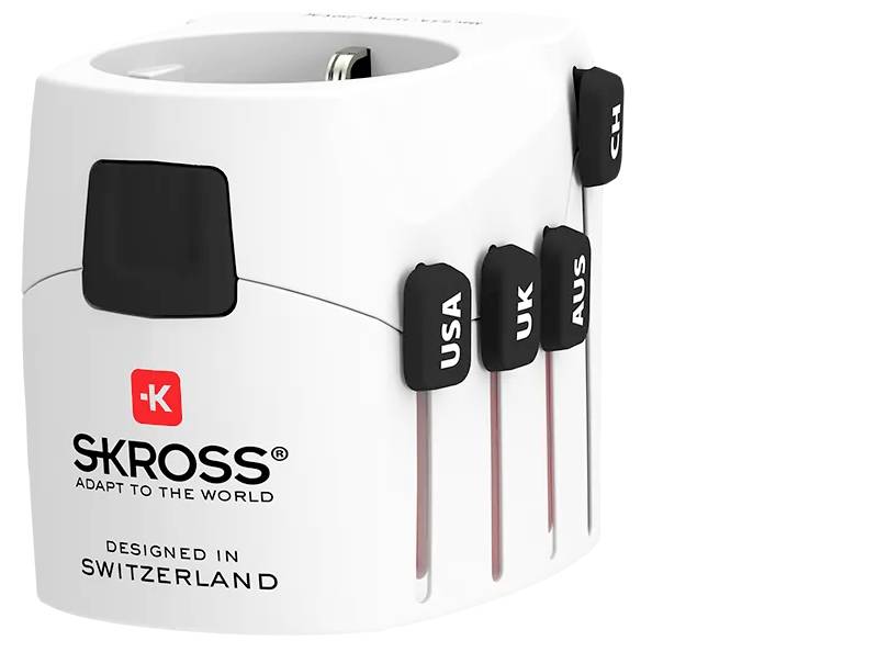 Bílý cestovní adaptér s logy 'SKROSS' a 'Designed in Switzerland'; na levé straně jsou zobrazeny zástrčky pro USA, UK, AUS a CH.