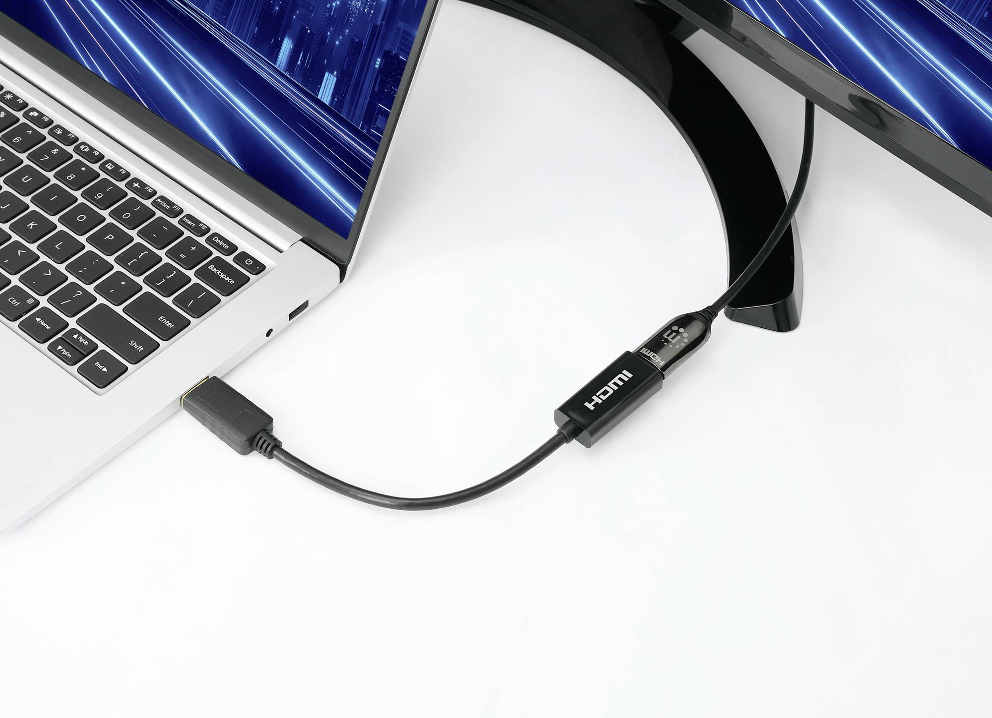 HDMI kabel propojuje notebook s monitorem za účelem rozšíření obrazovky. Oba displeje zobrazují abstraktní modrý vzor.