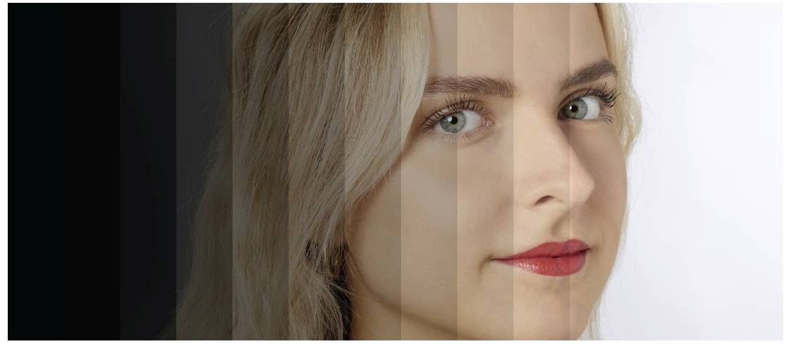 Žena s blonďatými vlasy. Obraz ukazuje přechod z tmavého do světlého pozadí, který částečně zastírá obličej.