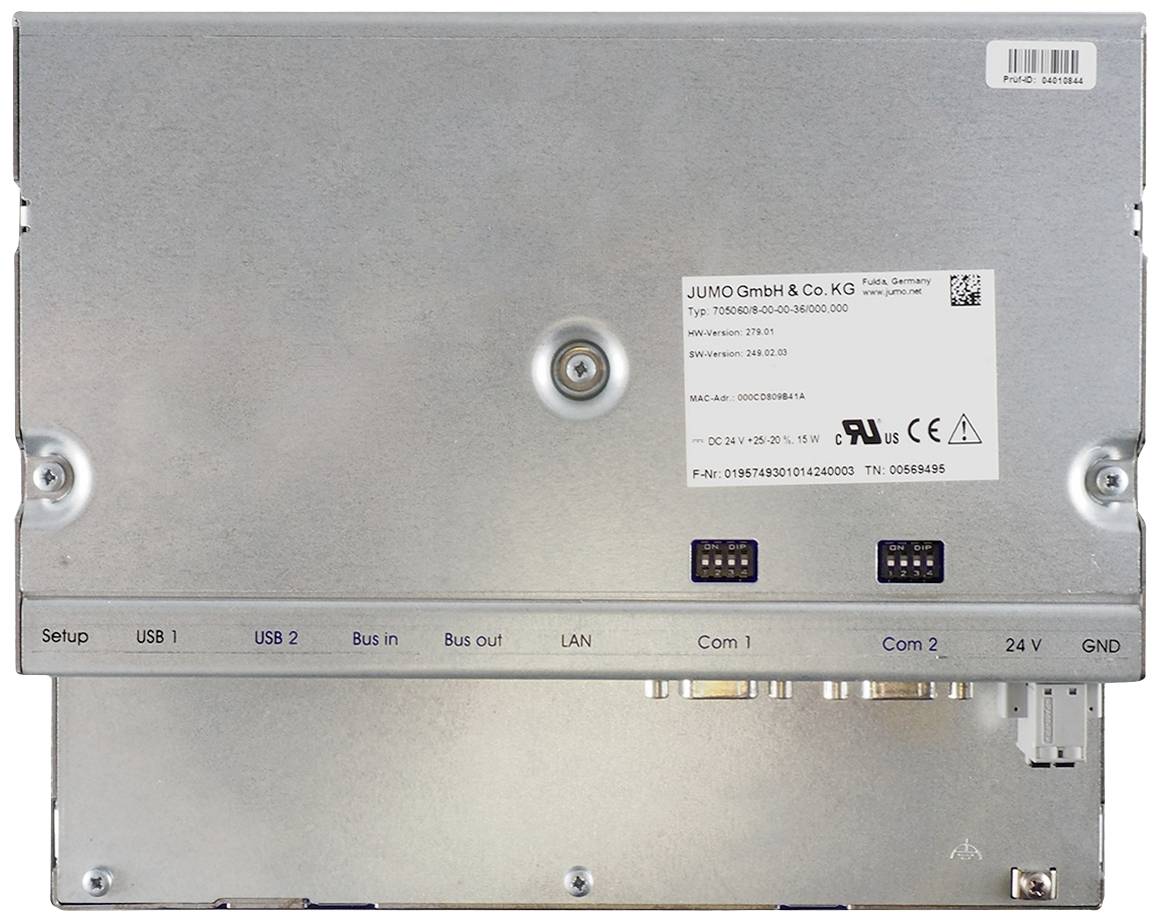 Zadní pohled na elektronické zařízení s kovovým tělem, výřezem pro štítek a několika konektory pro USB, LAN a napájení.