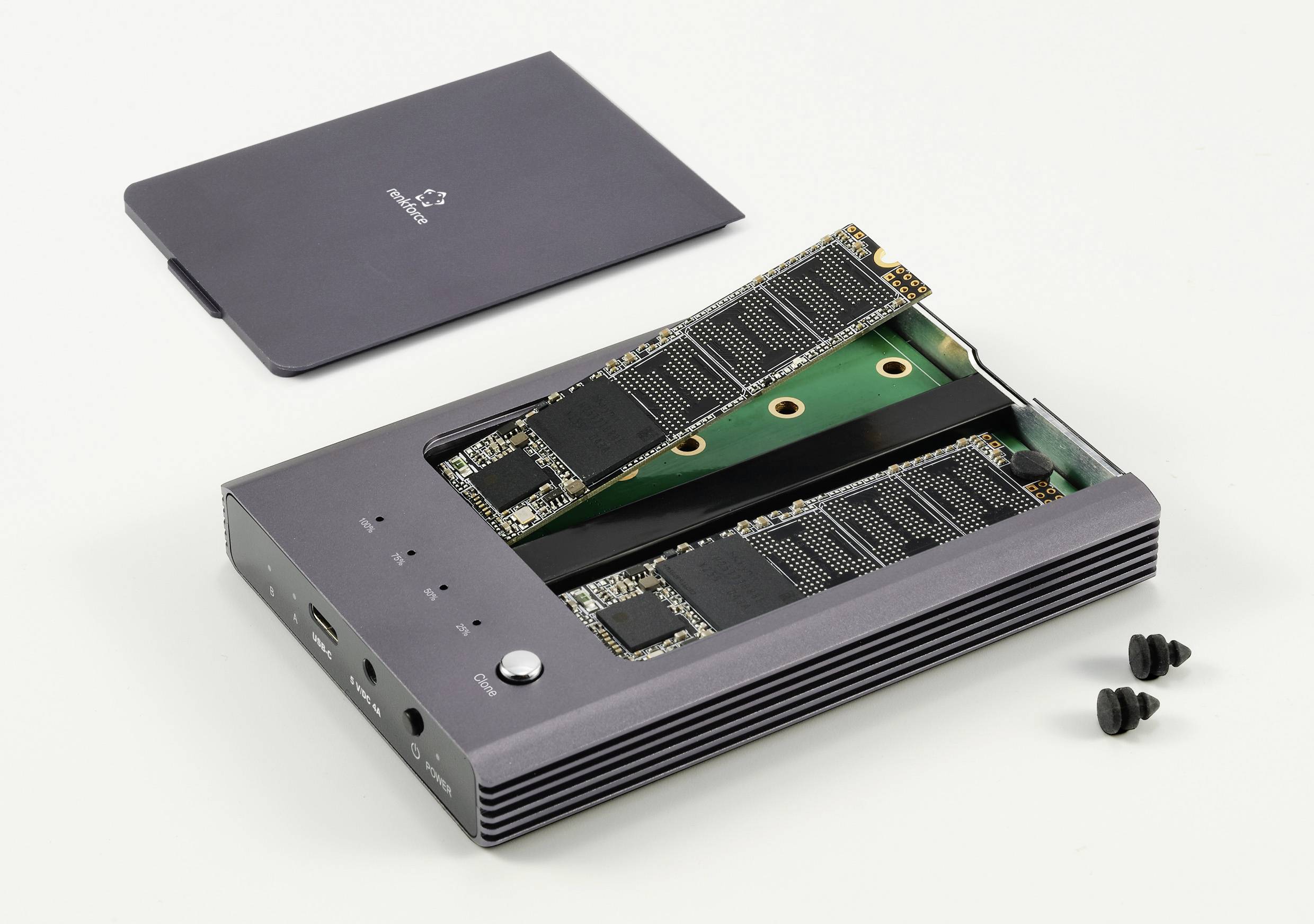 Externí pevný disk se dvěma volně umístěnými M.2 SSD; kryt skříně a šrouby leží vedle.
