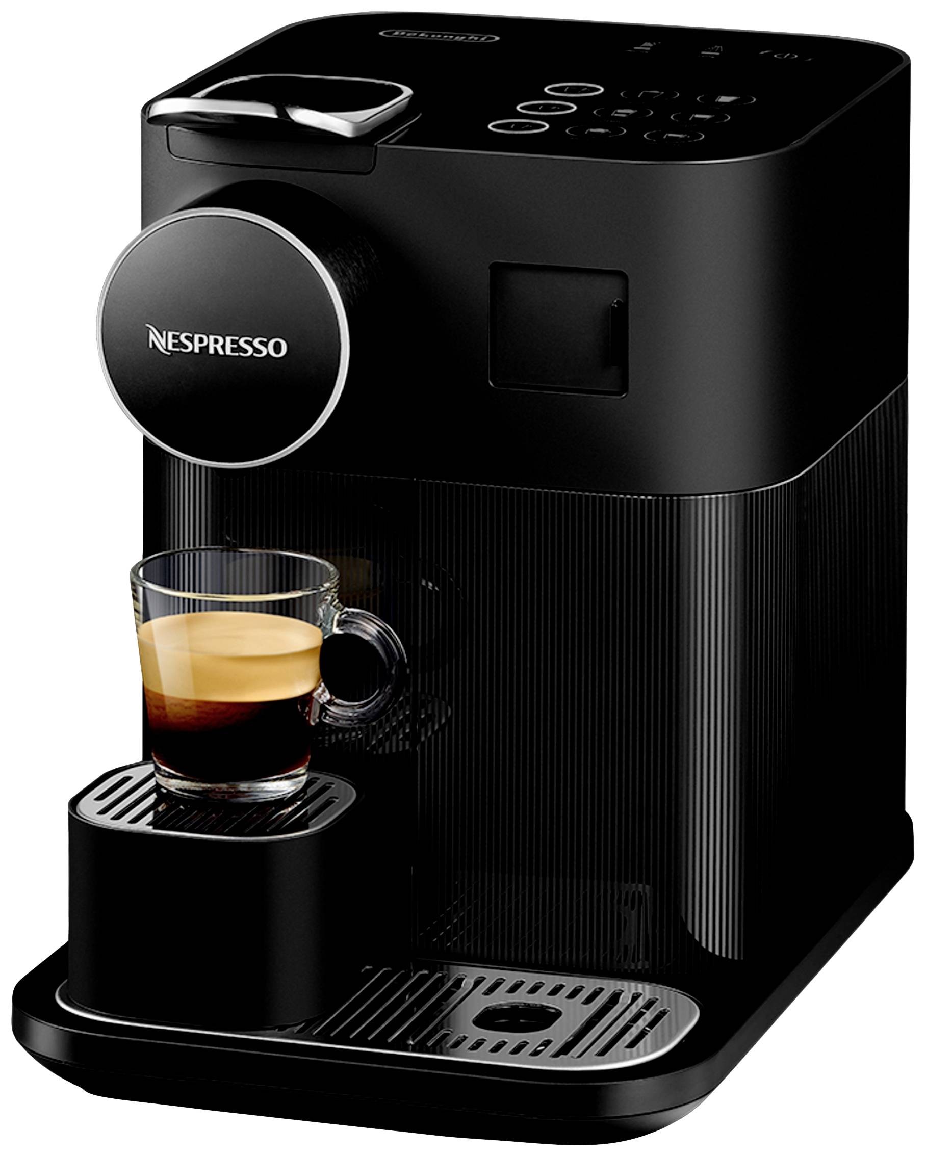 Černý kávovar Nespresso s espresem v šálku na odkapávací ploše.