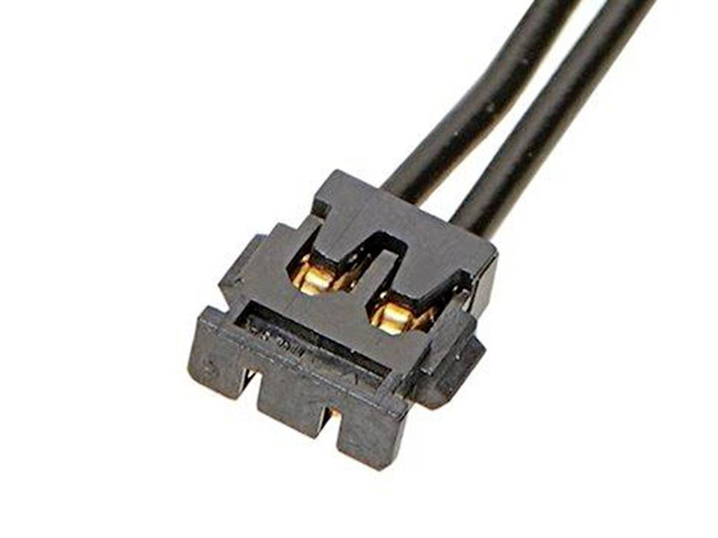 Černý elektronický konektor se dvěma póly se zlatými kontakty a krátkými vodiči pro elektrické připojení.