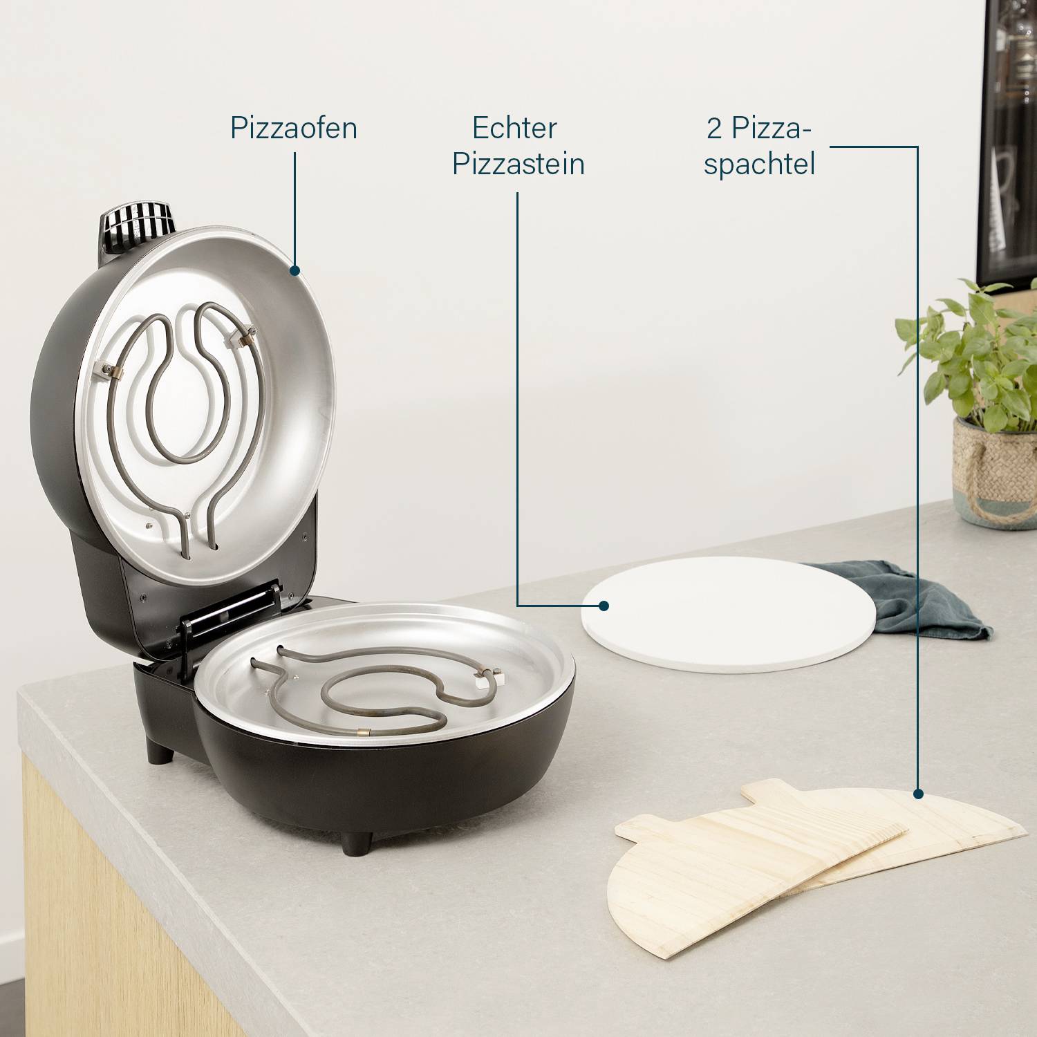 Pizzová pec s otevřeným víkem, obsahující pravý pizzový kámen. Vedle leží dvě pizzové stěrky na stolní desce.