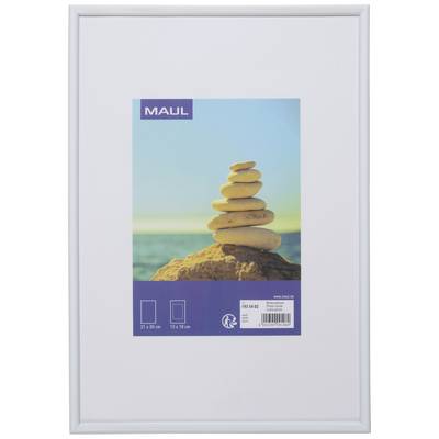 Bílý rámeček s fotografií navzájem naložených kamenů u moře. Obraz má rozměry 21 x 30 cm.