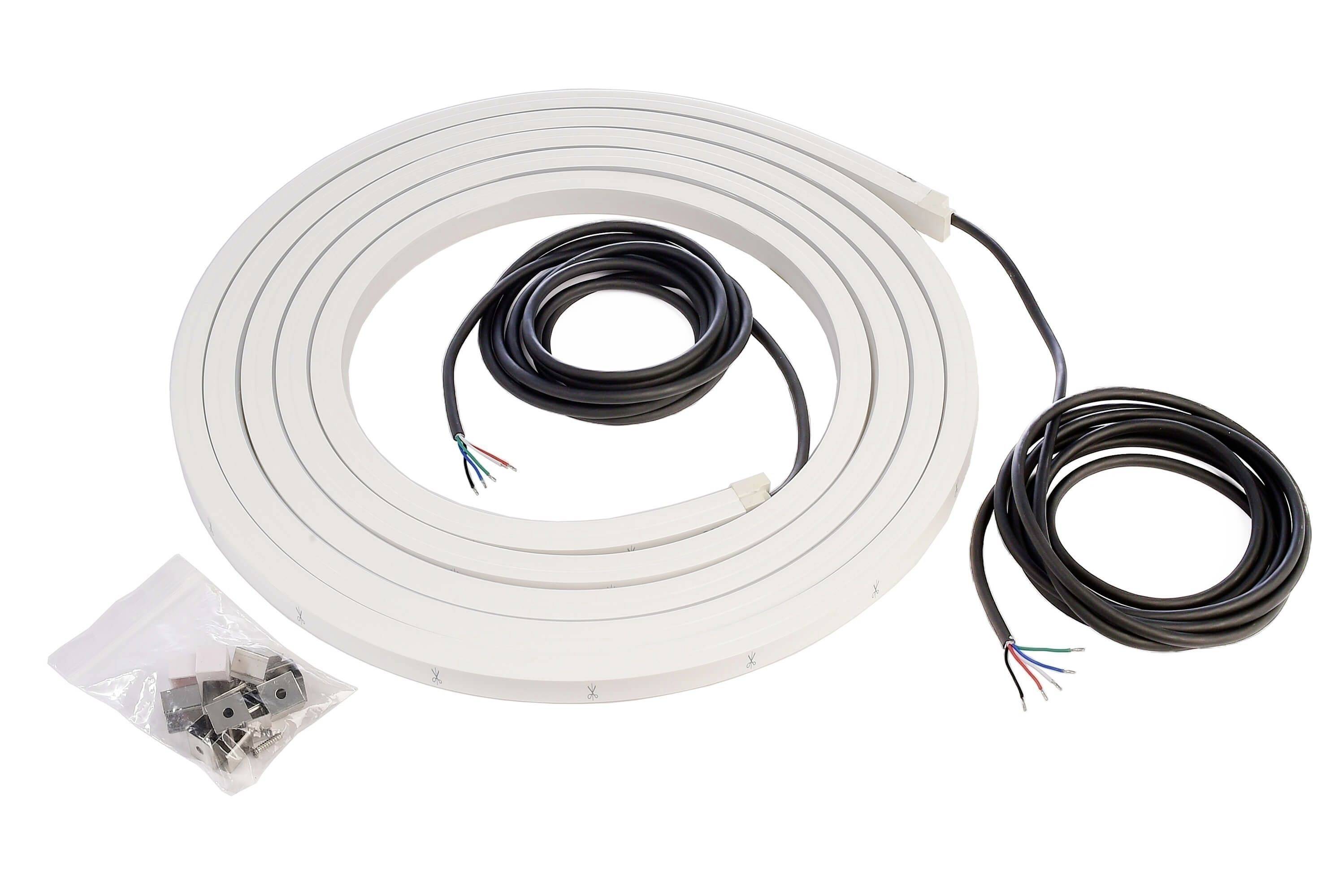 Bílý, zvlněný LED pásek se dvěma kabely pro připojení a sáček s montážním materiálem.