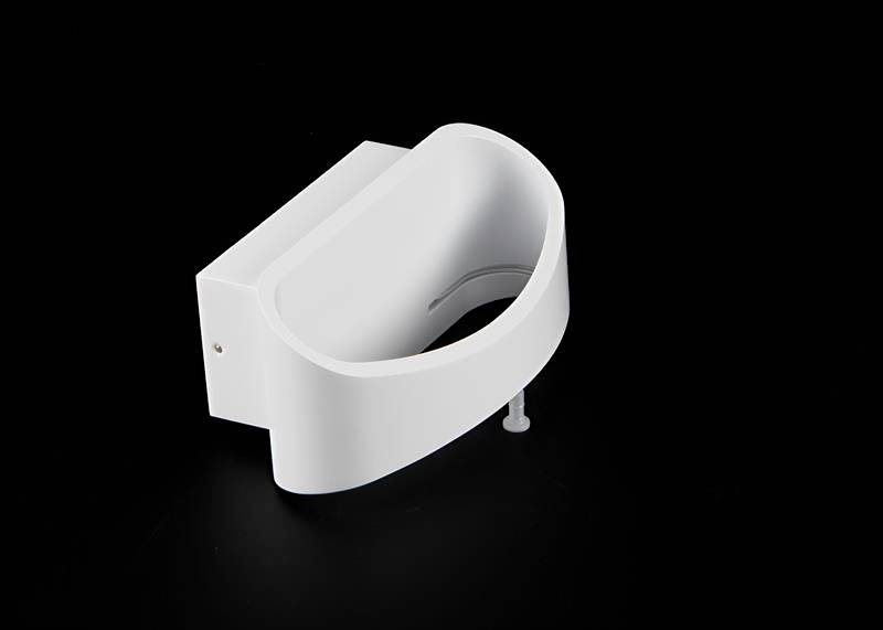 Bílá, moderní nástěnná lampa s oblým, minimalistickým designem na černém pozadí.