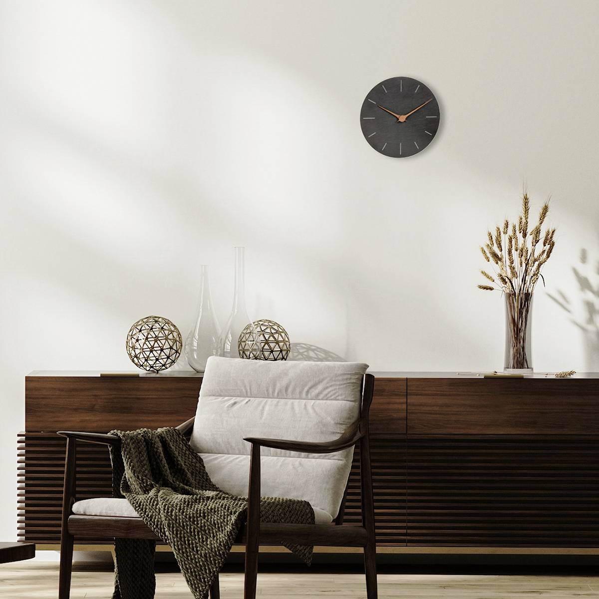 Světlý prostor s dřevěnou kreditní skříňkou, vyzdobený moderními kulovými lampami, váhou s větvemi a nástěnými hodinami.