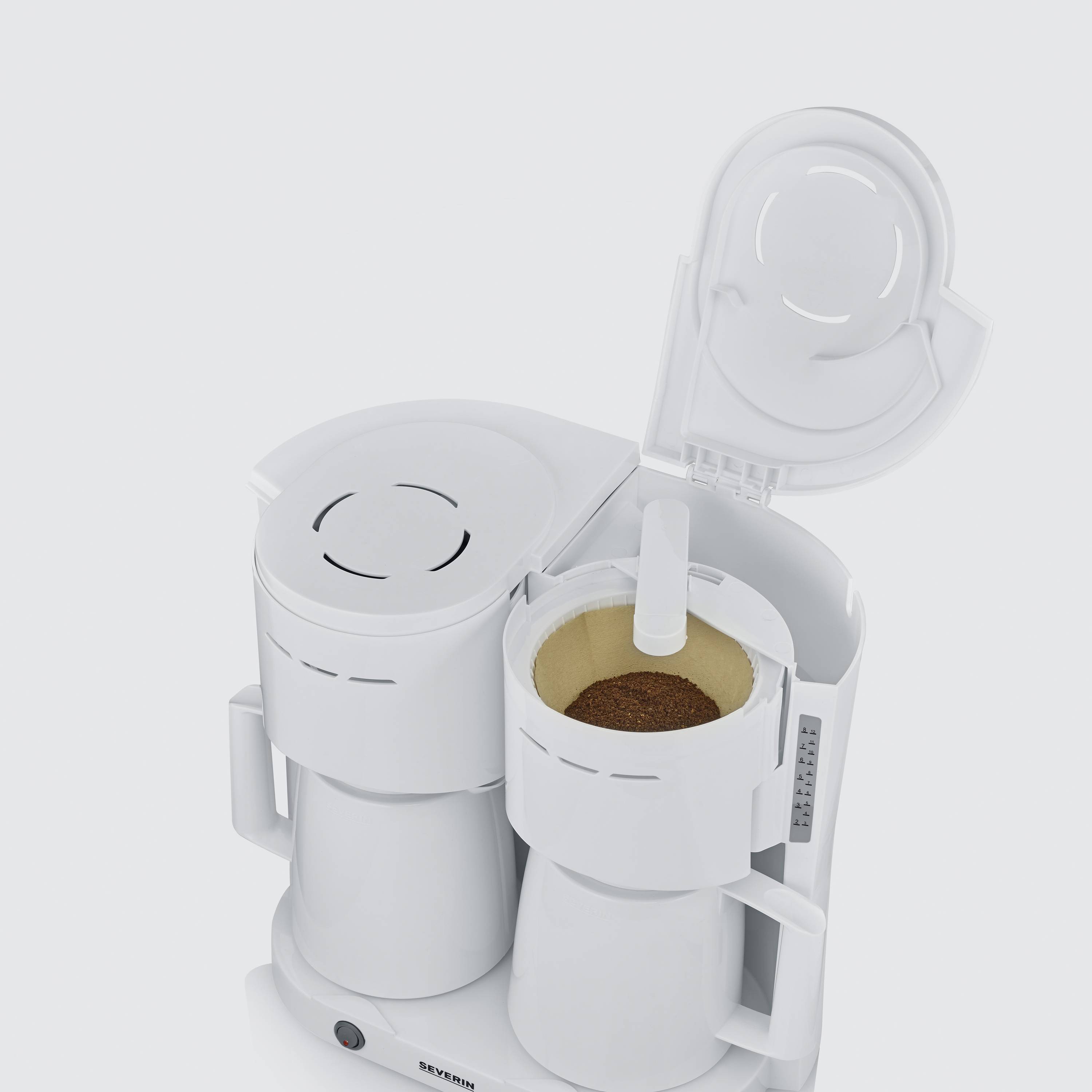 Bílý kávovar s otevřeným víkem je zobrazen, naplněný kávovou drtí v papírovém filtru.