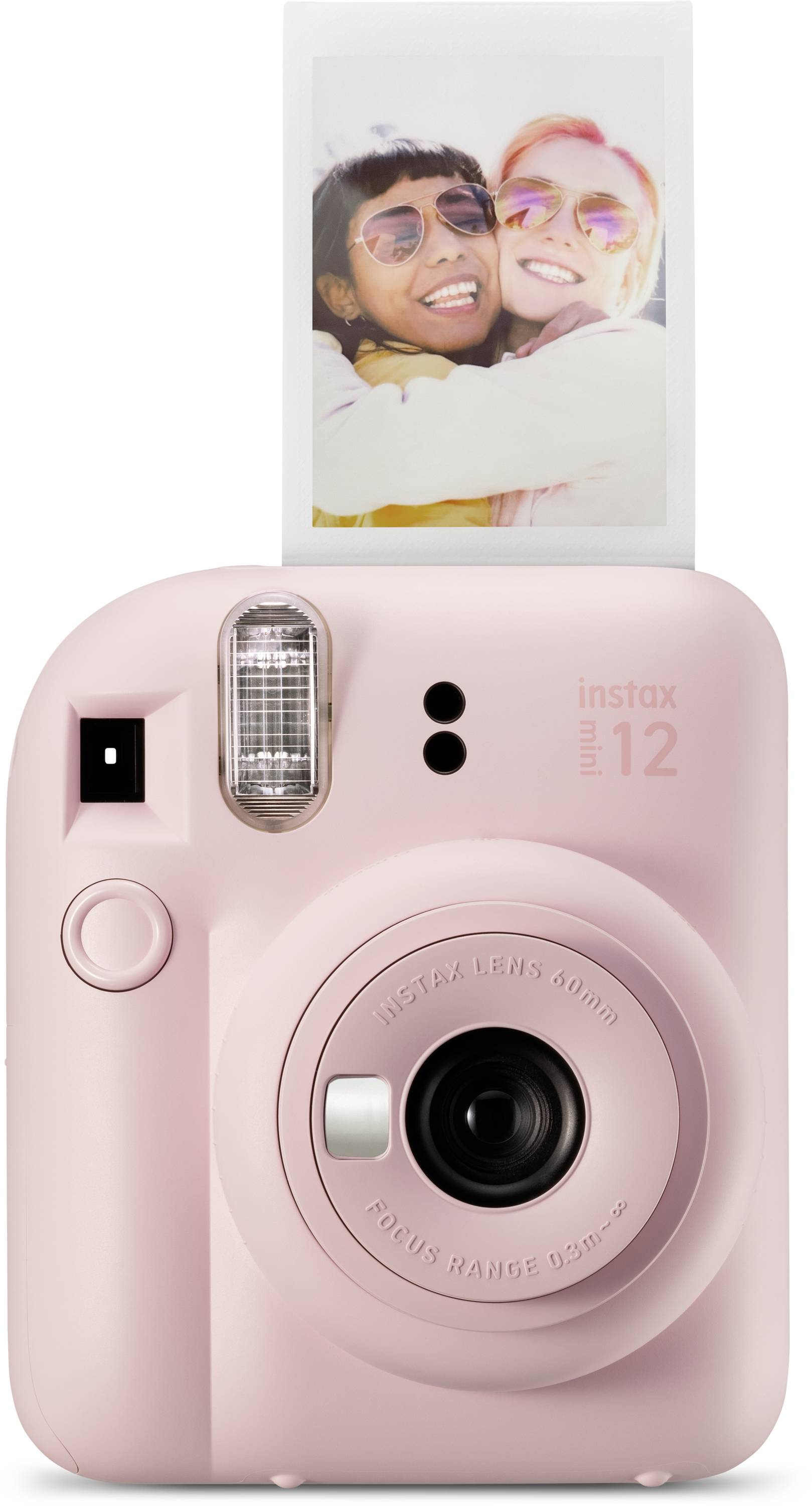 Růžový instantní fotoaparát tiskne fotografii dvou osob, které se smějí a pózují.