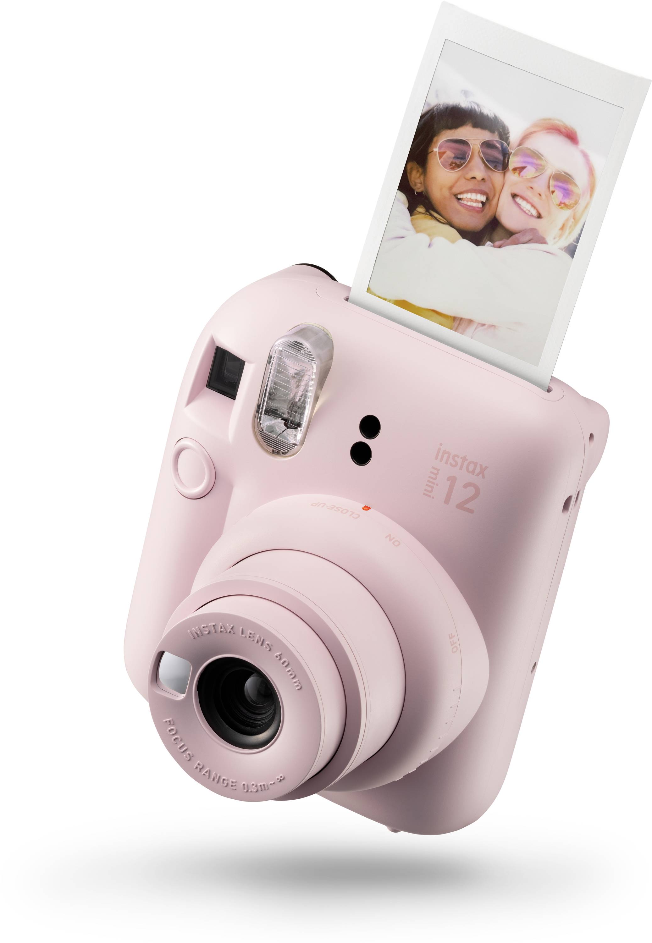 Růžový instantní fotoaparát s vytištěnou fotografií dvou veselých osob.
