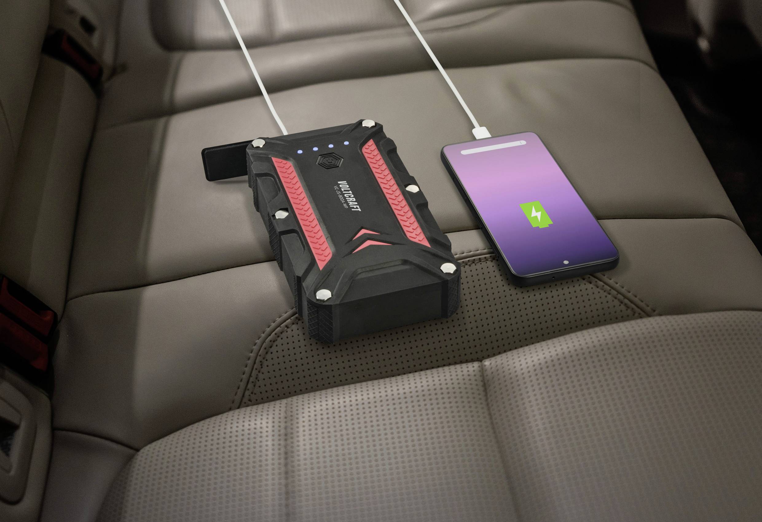Externí powerbanka na sedadle auta nabíjí smartphone.