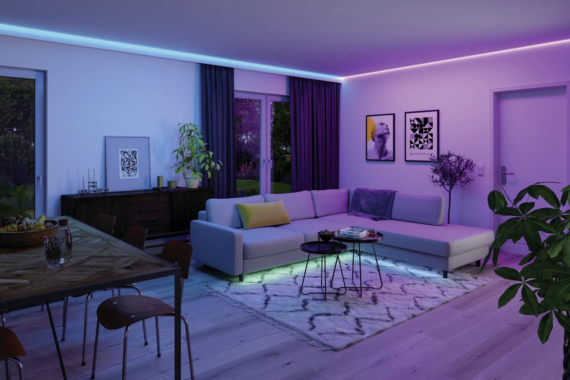 Moderní obývací pokoj s LED osvětlením, šedou pohovkou a barevným kobercem. Elegantní interiér s rostlinami a nástěnnými obrazy.