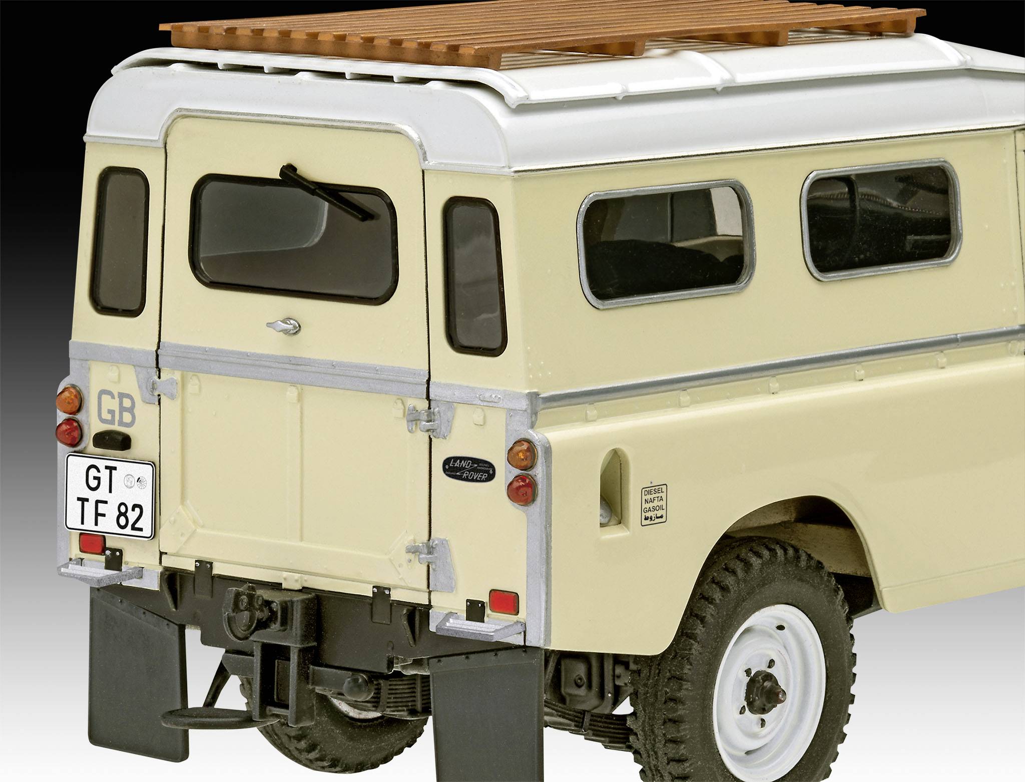 Žlutý Land Rover Defender zezadu, s rezervním kolem a britskou registrační značkou. Je patrný dřevěný střešní nosič.