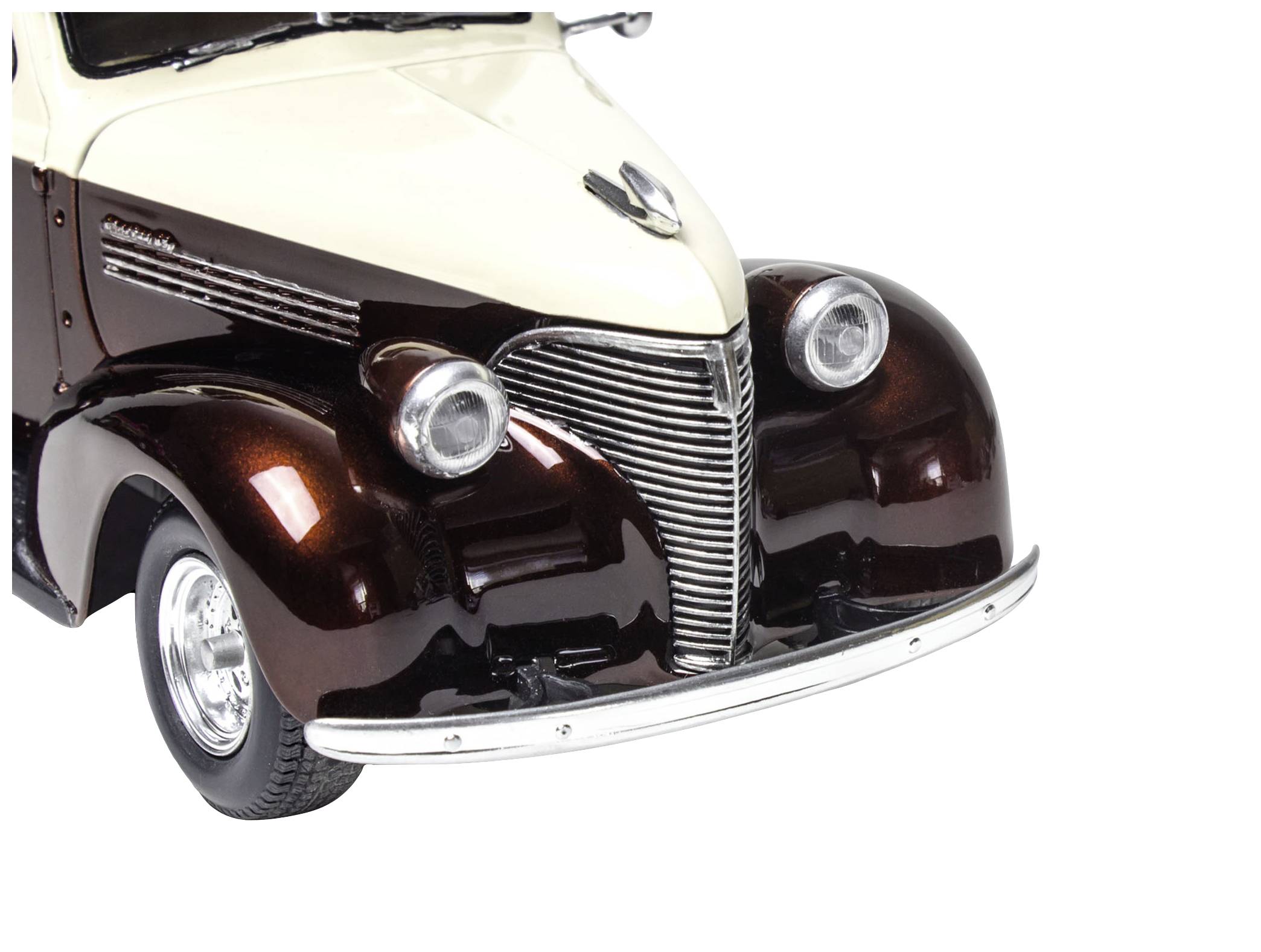 Model klasického osobního automobilu v dvoubarevném designu, krémové a hnědé barvy. Přední část vozu ukazuje kulaté světlomety a chladič.