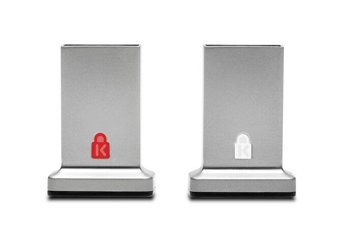 Dva stříbrné počítačové zámky k laptopům s červenými a bílými symboly na přední straně, které se používají pro bezpečnostní systémy.