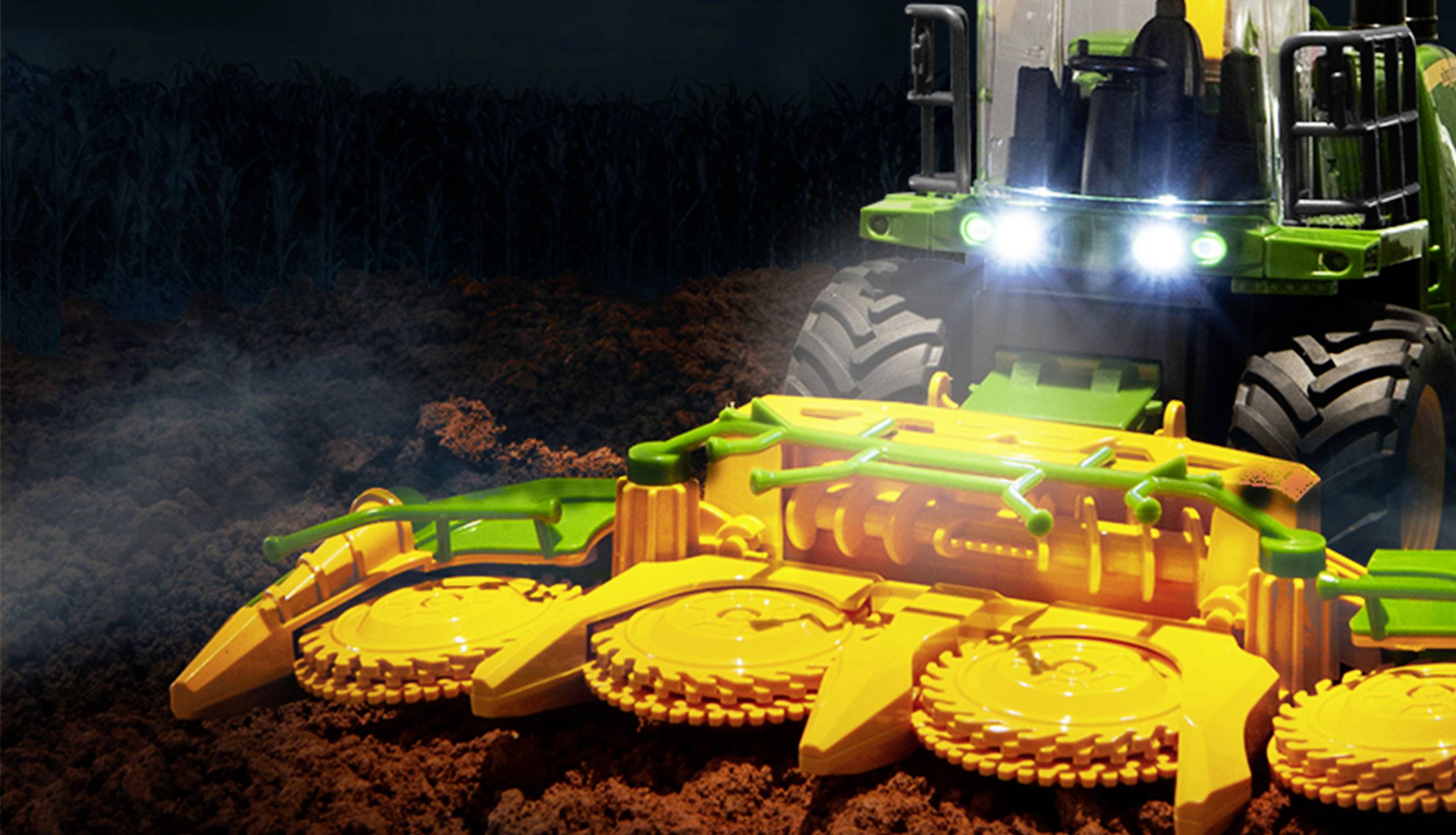 Traktor na poli v noci se svítícími reflektory, obdělávání půdy s velkým žlutým zemědělským strojem v popředí.