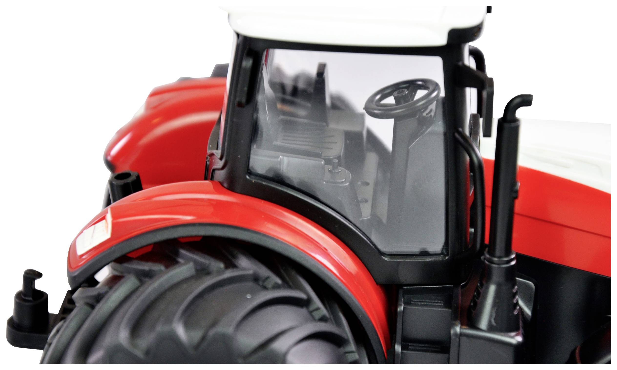 Červený traktor s bílou kabinou a černými koly, fotografovaný zezadu. Je vidět volant a sedadlo řidiče.