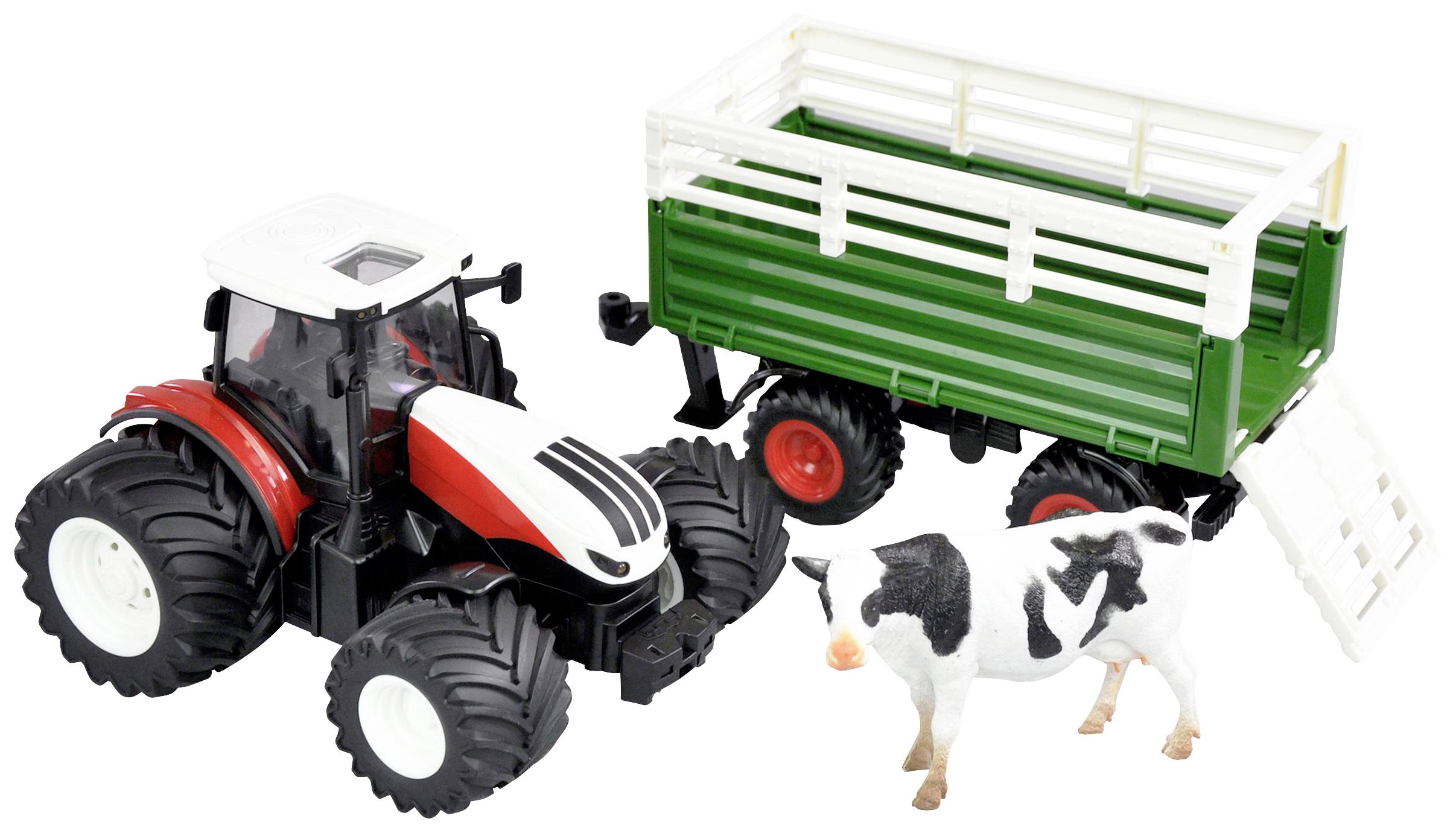 Hračkový traktor s přívěsem vedle figurky krávy. Traktor je červeno-bílý, přívěs zelený a kráva černobílá.