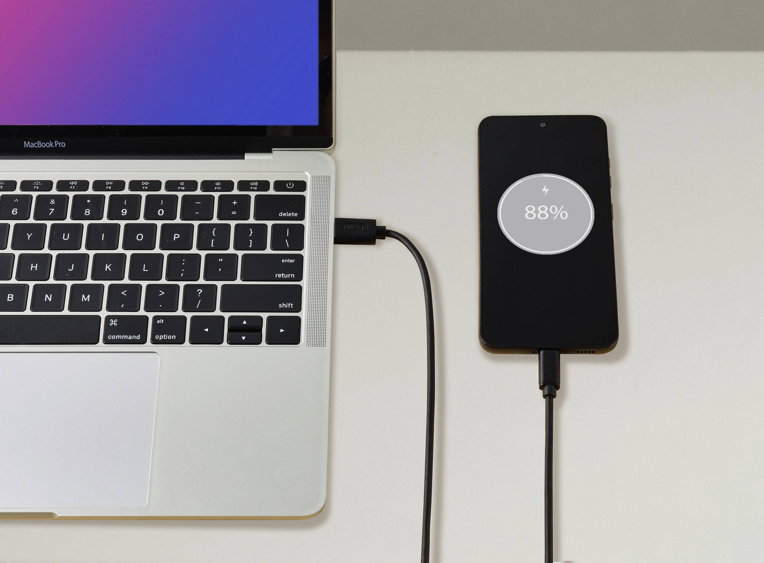 Laptop a smartphone jsou propojeny. Smartphone se nabíjí a zobrazuje 88% stavu baterie.