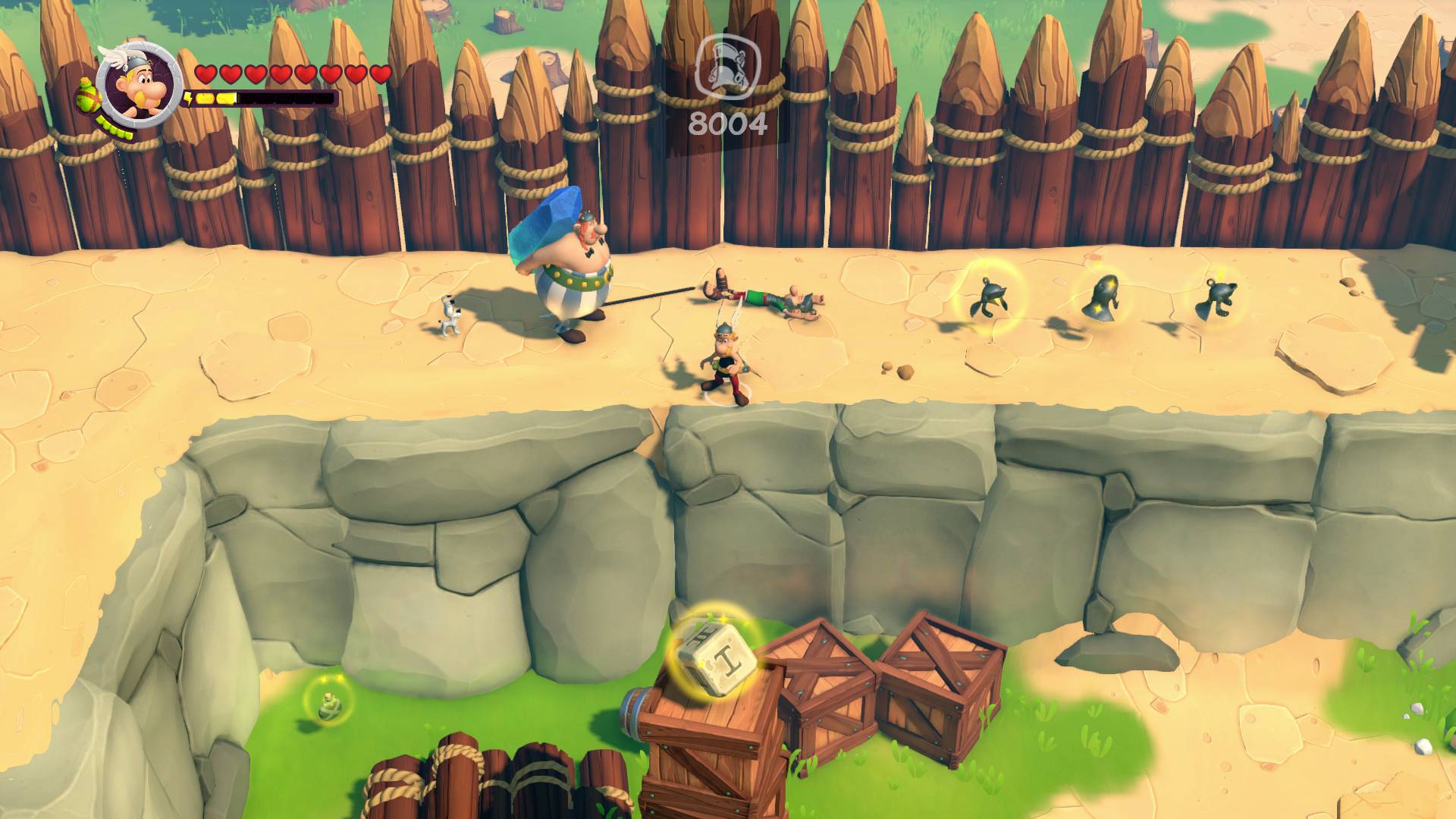 Herní scéna: Postava bojuje s malými bytostmi před dřevěným plotem. Skóre: 8004. Prostředí: Písčitá zem, bedny.