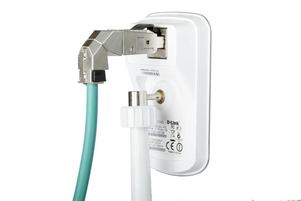 Bílé zařízení s ethernetovým připojením a koaxiálním kabelem, pravděpodobně síťový prvek nebo modem.